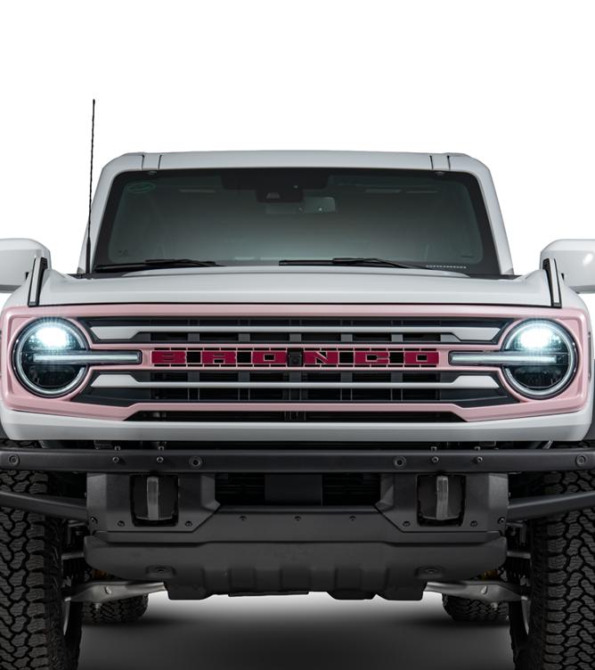 Front view of a white Bronco with a DIY grille featuring a unique two-tone pink and red painted surround and BRONCO lettering.